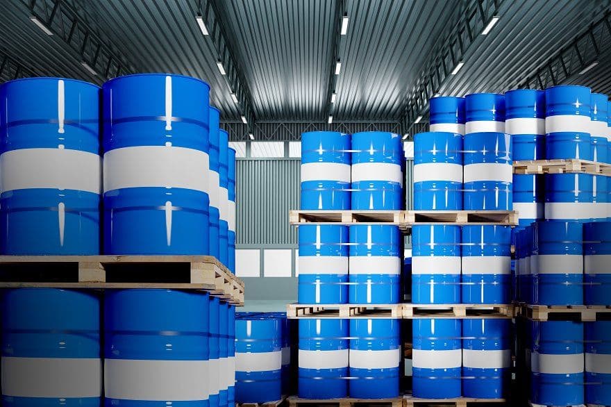 Palletised blue chemical drums stacked in a distribution store